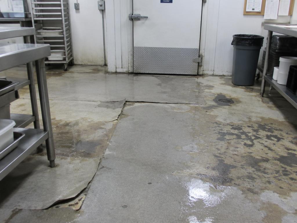 Worn food preparation area floor before polyurethane cement coating